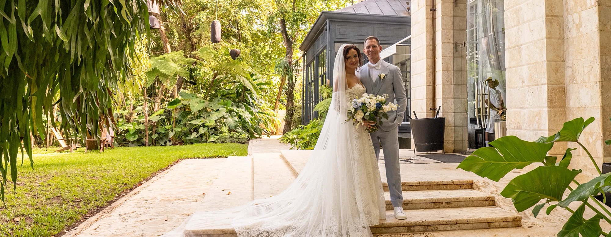Bride and groom walking through a lush villa courtyard, Dominican Republic